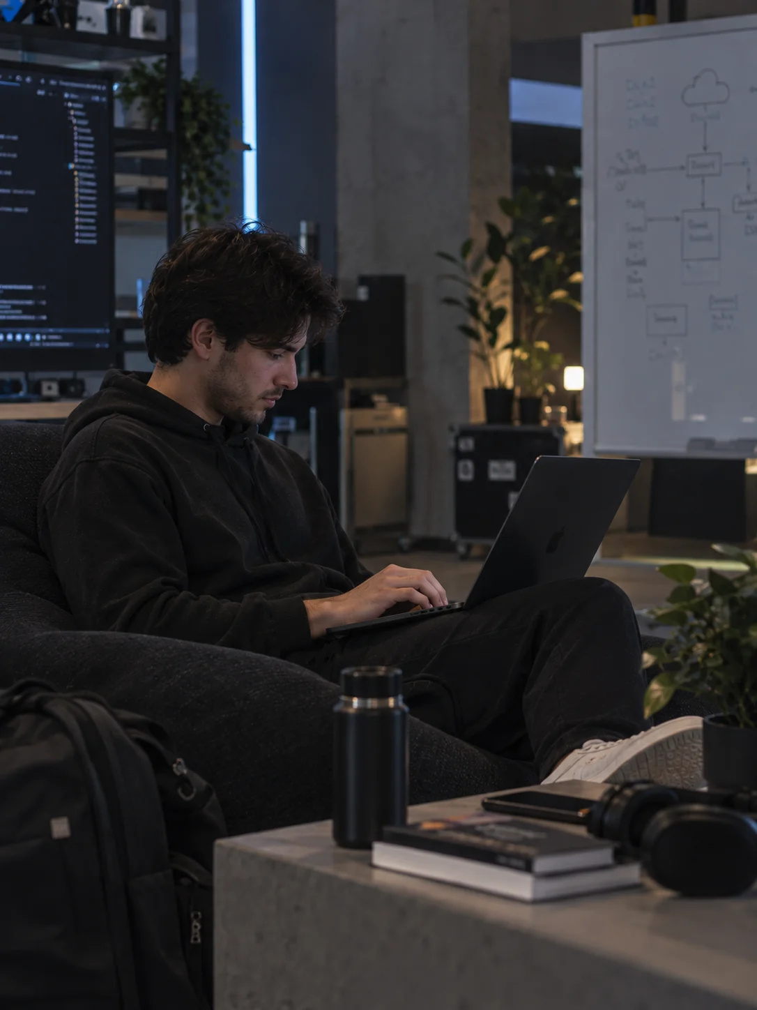 Desarrollador de Mainatek trabajando desde su computador, con un diagrama de arquitectura en la nube al fondo